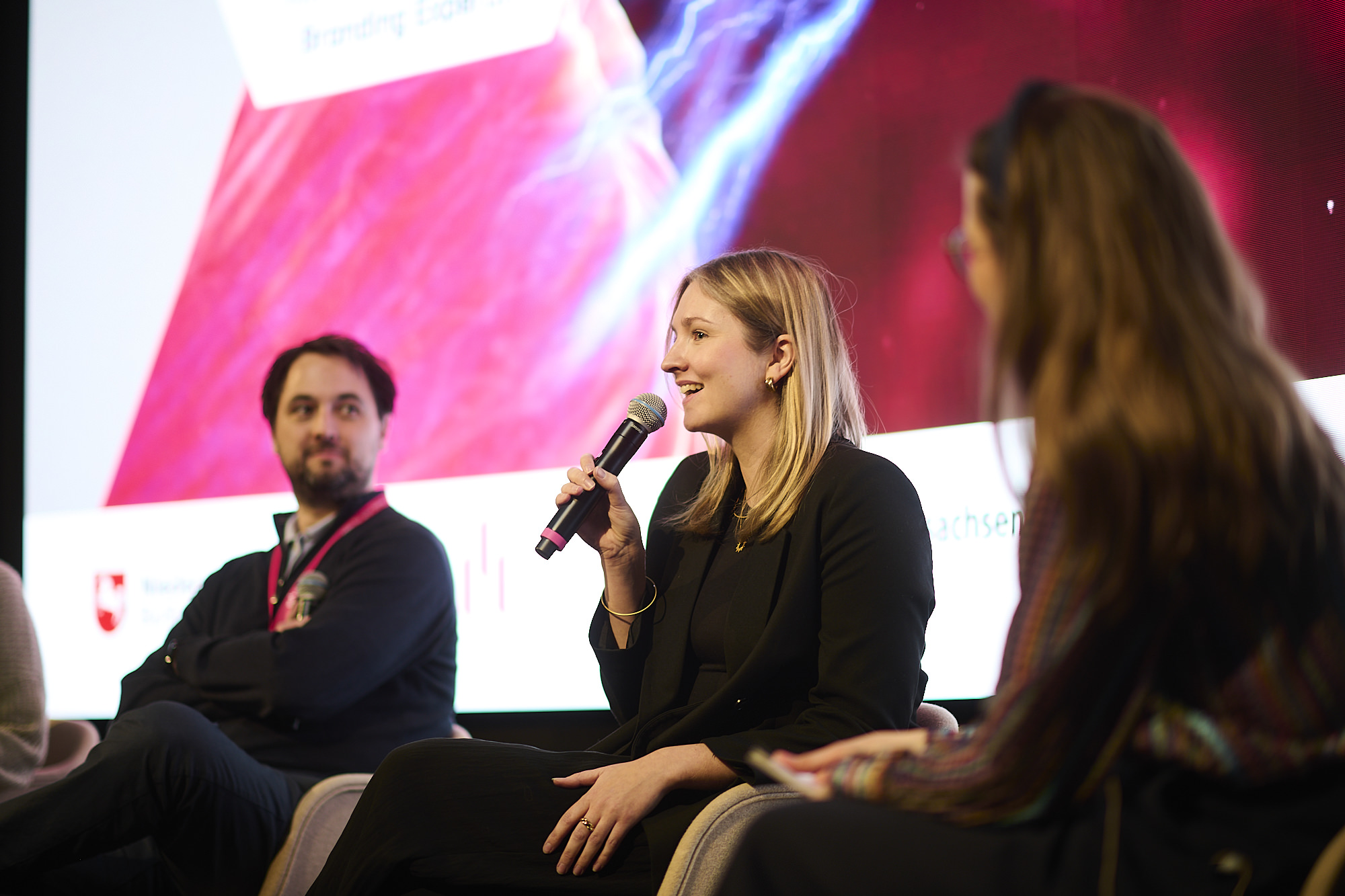 Kira Plagemann bei einem Konferenz-Panel mit Mikrofon